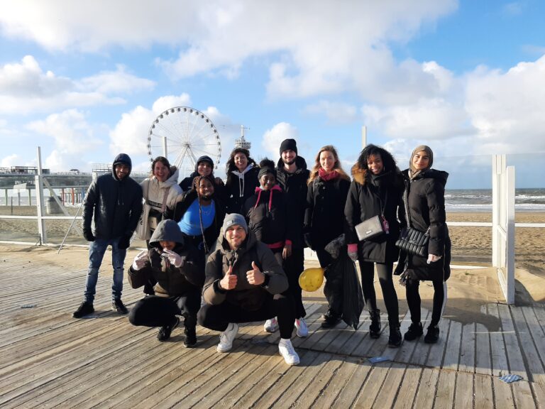 Groep jongeren poseren voor de pier in Scheveningen.